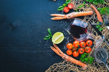 Deniz ürünleri ve bir kadeh şarap ahşap arka plan üzerinde. Üstten Görünüm. Metniniz için boş alan.