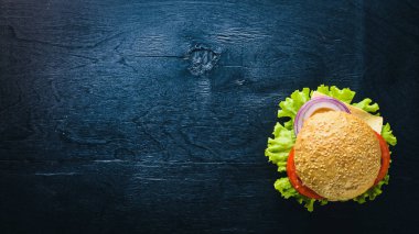 Peynir, et, domates ve soğan ve otlar ile hamburger. Ahşap arka plan üzerinde. Üstten Görünüm. Boş alan.