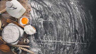 Ekmek, peynir ekşi krema, süt, un, yumurta için hazırlık. Siyah ahşap arka plan üzerinde. Üstten Görünüm. Boş alan.