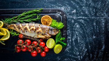 Alabalık balık pişmiş aromatik otlar ve baharatlar ile. Ahşap arka plan üzerinde.