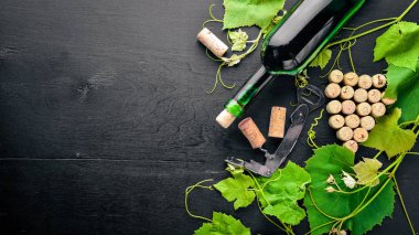 Üzüm cinayet sebebi. Bir şişe, bir bardak şarap ve üzüm yaprakları. Üstten Görünüm. Boş alan.