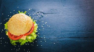 Peynir, et, domates ve soğan ve otlar ile hamburger. Ahşap arka plan üzerinde. Üstten Görünüm. Boş alan.