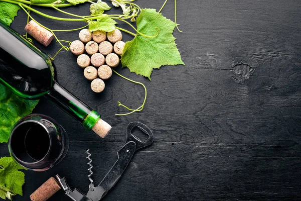 Üzüm cinayet sebebi. Bir şişe, bir bardak şarap ve üzüm yaprakları. Üstten Görünüm. Boş alan.