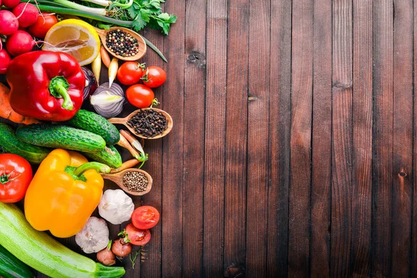 Organik gıda çerçevesinde. Taze çiğ sebze ve baharat. Ahşap tahta.