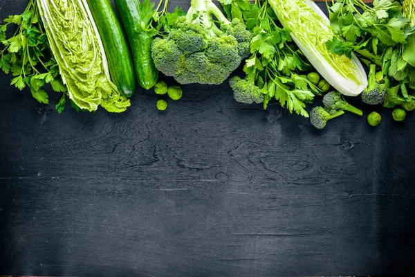 Kara taş üzerine yerleştirilmiş taze yeşil sebze topluluğu