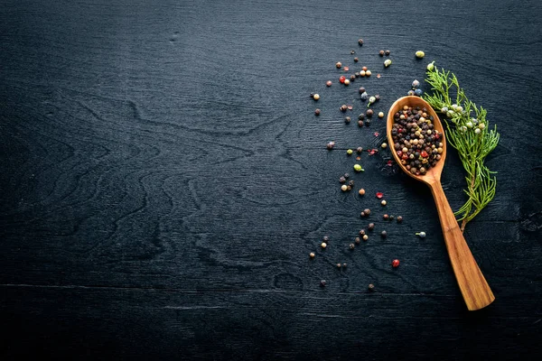 Güzel kokulu baharatlar kümesi. Siyah ve kırmızı biber, kişniş, kırmızı biber karışımı. Ahşap arka plan üzerinde. Üstten Görünüm. Boş alan.