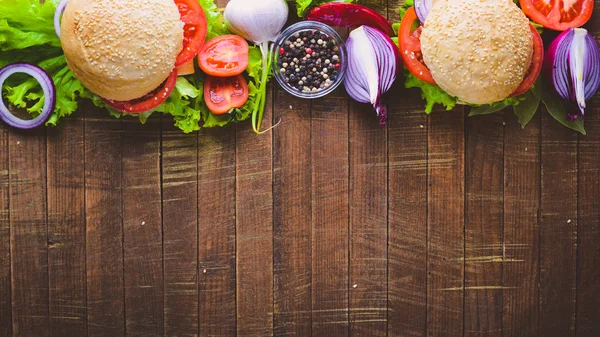 Peynir, et, domates ve soğan ve otlar ile hamburger. Ahşap arka plan üzerinde. Üstten Görünüm. Boş alan