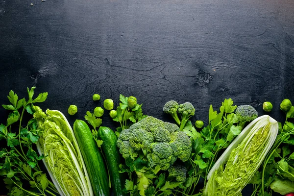 Kara taş üzerine yerleştirilmiş taze yeşil sebze topluluğu