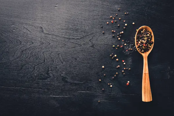 Güzel kokulu baharatlar kümesi. Siyah ve kırmızı biber, kişniş, kırmızı biber karışımı. Ahşap arka plan üzerinde. Üstten Görünüm. Boş alan.