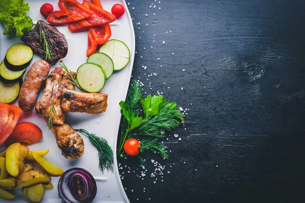 Çeşitli ızgara et ve sebze dilimlenmiş. Ahşap bir arka plan üzerinde. Üstten Görünüm. Metniniz için boş alan.