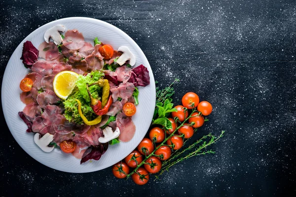 Carpaccio sığır eti, sebze, peynir, baharatlar, ahşap arka plan için. Üstten Görünüm. Boş alan