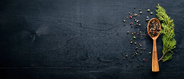 Güzel kokulu baharatlar kümesi. Siyah ve kırmızı biber, kişniş, kırmızı biber karışımı. Ahşap arka plan üzerinde. Üstten Görünüm. Boş alan.