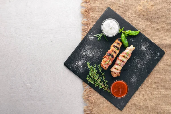 Rulo tavuk fileto ve pastırma. Ahşap bir arka plan üzerinde. En iyi bir daha gözden geçirme. Boş alan.