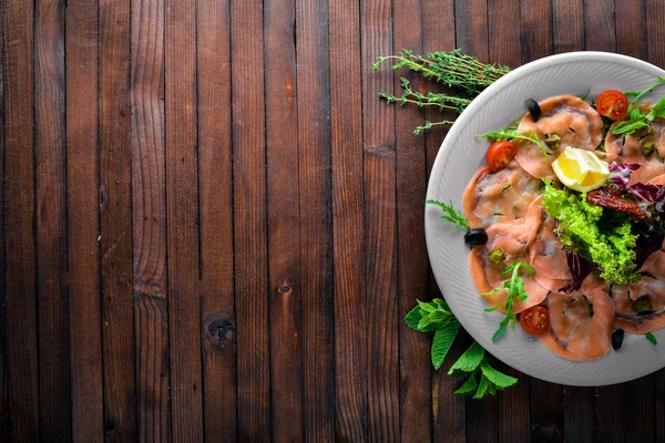 Carpaccio balık, sebze, peynir, baharatlar, ahşap arka plan için. Üstten Görünüm. Boş alan.