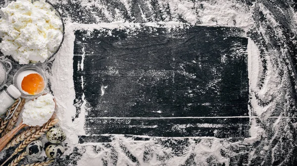 Ekmek, peynir ekşi krema, süt, un, yumurta için hazırlık. Siyah ahşap arka plan üzerinde. Üstten Görünüm. Boş alan.