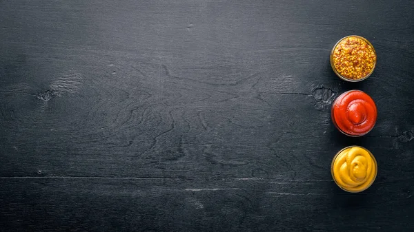 Ketçap ve hardal ahşap arka plan üzerinde baharatlar. Üstten Görünüm. Boş alan.