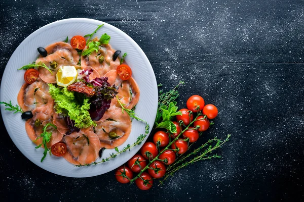 Carpaccio balık, sebze, peynir, baharatlar, ahşap arka plan için. Üstten Görünüm. Boş alan.