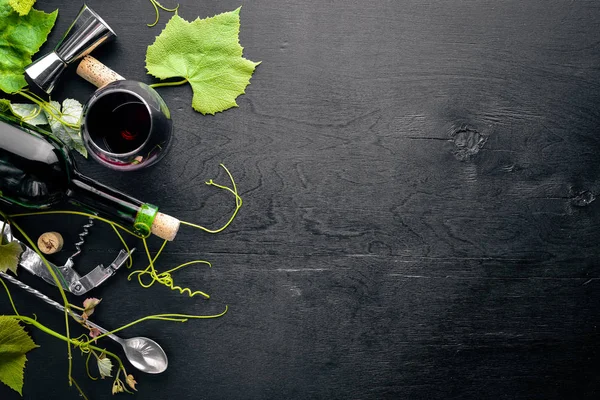 Un movente d'uva. Una bottiglia e un bicchiere di vino e foglie d'uva. Vista dall'alto. Spazio libero . — Foto Stock