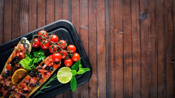 Bruschetta med tomater, oliver, örter och parmesanost på brödet. Kalla snacks. Italienska rätter. På trä bakgrund. — Stockfoto