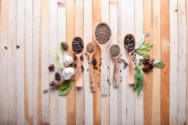 Güzel kokulu baharatlar kümesi. Siyah ve kırmızı biber, kişniş, kırmızı biber karışımı. Ahşap arka plan üzerinde. Üstten Görünüm. Boş alan.