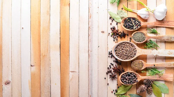 Güzel kokulu baharatlar kümesi. Siyah ve kırmızı biber, kişniş, kırmızı biber karışımı. Ahşap arka plan üzerinde. Üstten Görünüm. Boş alan.