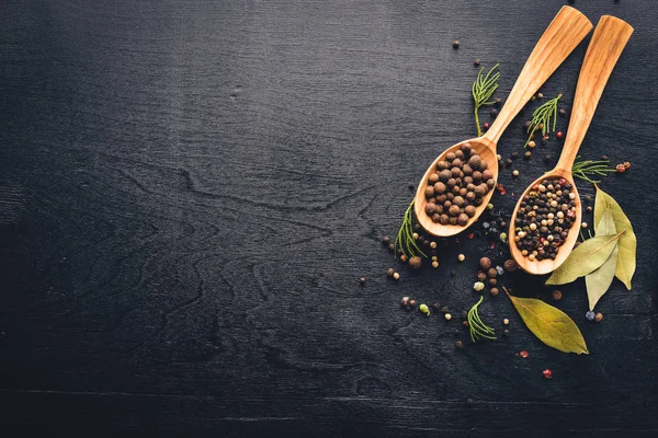 Güzel kokulu baharatlar kümesi. Siyah ve kırmızı biber, kişniş, kırmızı biber karışımı. Ahşap arka plan üzerinde. Üstten Görünüm. Boş alan.