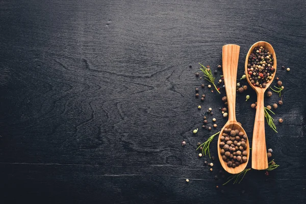 Güzel kokulu baharatlar kümesi. Siyah ve kırmızı biber, kişniş, kırmızı biber karışımı. Ahşap arka plan üzerinde. Üstten Görünüm. Boş alan.