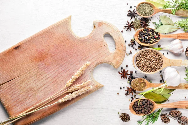 Güzel kokulu baharatlar kümesi. Siyah ve kırmızı biber, kişniş, kırmızı biber karışımı. Ahşap arka plan üzerinde. Üstten Görünüm. Boş alan.