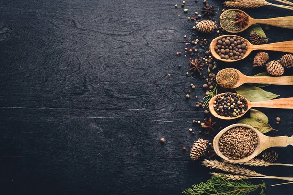 Güzel kokulu baharatlar kümesi. Siyah ve kırmızı biber, kişniş, kırmızı biber karışımı. Ahşap arka plan üzerinde. Üstten Görünüm. Boş alan.