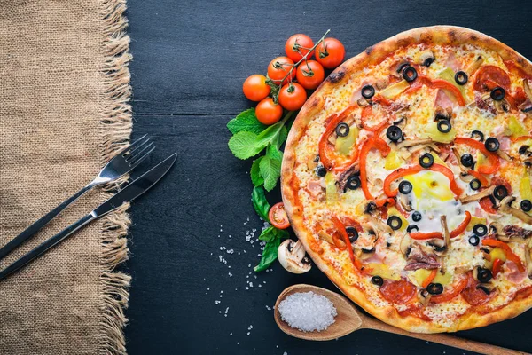Sebzeli pizza. Ahşap bir arka plan üzerinde. Üstten Görünüm. Metniniz için boş alan.
