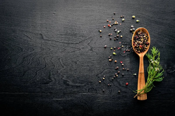 Güzel kokulu baharatlar kümesi. Siyah ve kırmızı biber, kişniş, kırmızı biber karışımı. Ahşap arka plan üzerinde. Üstten Görünüm. Boş alan.