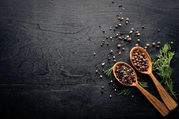 Güzel kokulu baharatlar kümesi. Siyah ve kırmızı biber, kişniş, kırmızı biber karışımı. Ahşap arka plan üzerinde. Üstten Görünüm. Boş alan.