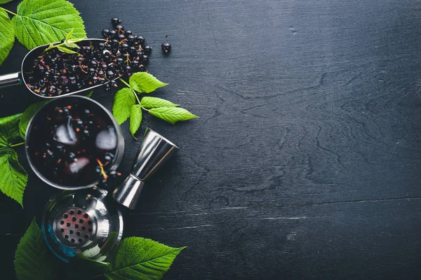 Ahşap arka plan üzerinde buz ile taze Siyah frenk üzümü kokteyl. Üstten Görünüm. Boş alan.