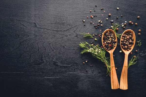 Güzel kokulu baharatlar kümesi. Siyah ve kırmızı biber, kişniş, kırmızı biber karışımı. Ahşap arka plan üzerinde. Üstten Görünüm. Boş alan.