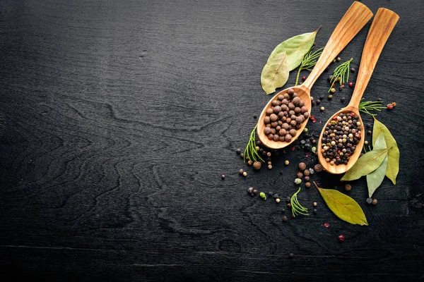 Güzel kokulu baharatlar kümesi. Siyah ve kırmızı biber, kişniş, kırmızı biber karışımı. Ahşap arka plan üzerinde. Üstten Görünüm. Boş alan.