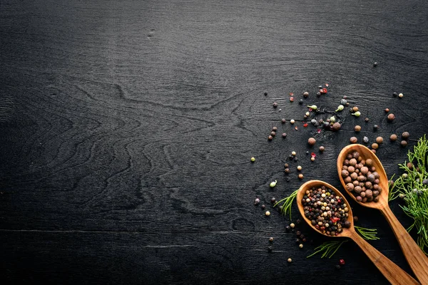 Güzel kokulu baharatlar kümesi. Siyah ve kırmızı biber, kişniş, kırmızı biber karışımı. Ahşap arka plan üzerinde. Üstten Görünüm. Boş alan.