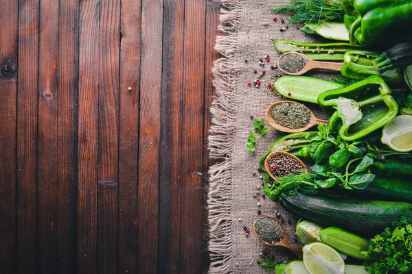 Yeşil sebzeler ve baharat ahşap arka plan üzerinde büyük bir seçim. Üstten Görünüm. Boş alan.