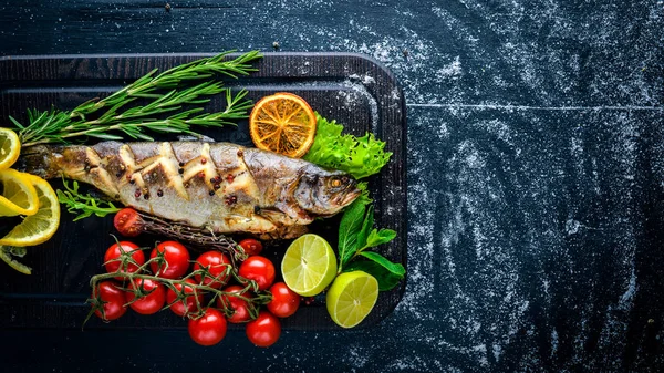 Alabalık balık pişmiş aromatik otlar ve baharatlar ile. Ahşap arka plan üzerinde.