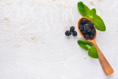 Bir tahta kaşık BlackBerry. Ahşap bir arka plan üzerinde. Üstten Görünüm. Metin için boş alan.