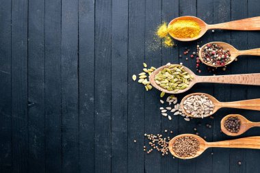 Çeşitli baharatlar kaşık taş masada. Ahşap bir gemide. Üstten Görünüm. Metniniz için boş alan.