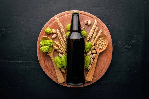 Una botella de cerveza, lúpulo y grano. Vista superior. Espacio libre para texto . — Foto de Stock