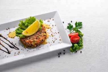 Tuzlanmış somon ve taze sebze bir tabak içinde balsamik soslu. Ahşap bir arka plan üzerinde. Üstten Görünüm. Boş alan.