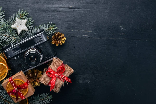 Camera Christmas wooden background. New Year\'s holiday. Christmas motive. On a wooden surface. Top view. Free space for your text.