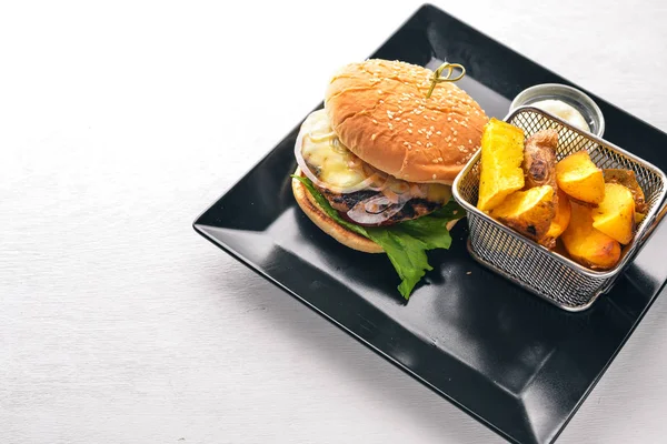 Sığır eti burger. Patates kızartma. Ahşap bir arka plan üzerinde. Üstten Görünüm. Metin için boş alan.