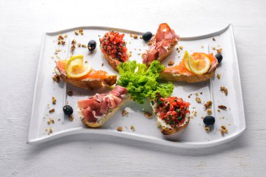 Bruschetta sandviç somon ve hamoon. Ahşap bir arka plan üzerinde. Üstten Görünüm. Boş alan.