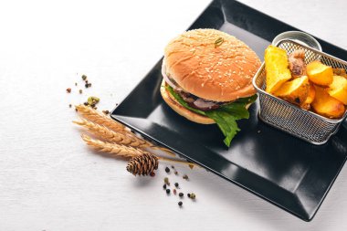 Sığır eti burger. Patates kızartma. Ahşap bir arka plan üzerinde. Üstten Görünüm. Metin için boş alan.