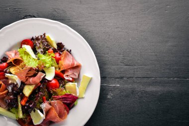 Sebze salatası ve doğranmış et. Ahşap bir arka plan üzerinde. Üstten Görünüm. Boş alan.