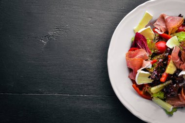 Sebze salatası ve doğranmış et. Ahşap bir arka plan üzerinde. Üstten Görünüm. Boş alan.