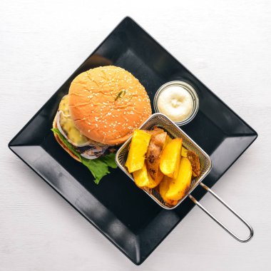 Sığır eti burger. Patates kızartma. Ahşap bir arka plan üzerinde. Üstten Görünüm. Metin için boş alan.