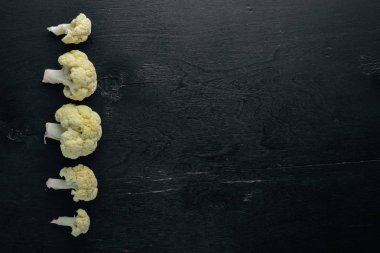 Karnabahar. Siyah ahşap arka plan üzerinde. Üstten Görünüm. Boş alan.